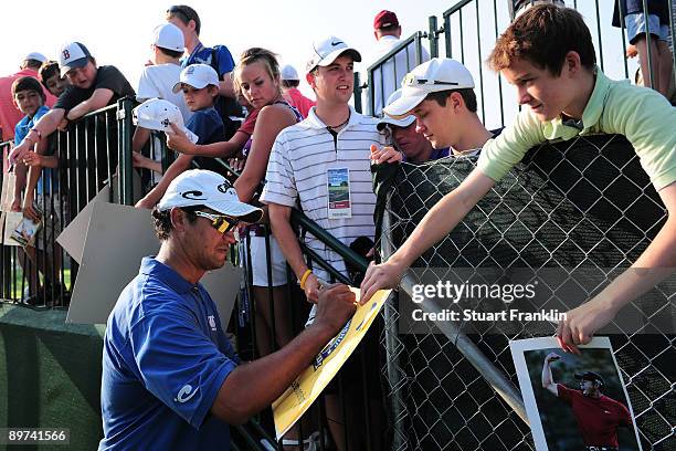 Michael Campbell of New Zealand signs his autograph for fans during the second preview day of the 91st PGA Championship at Hazeltine National Golf...