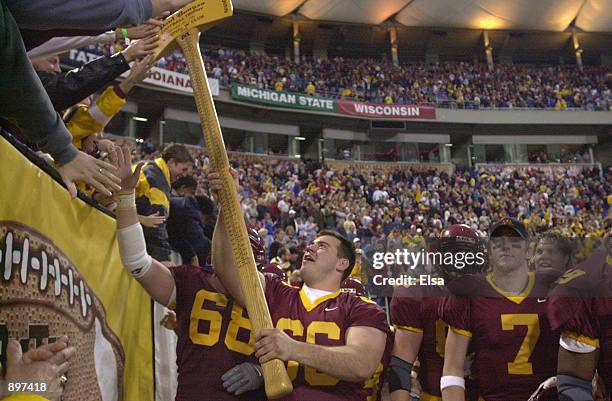 Offensive lineman Ryan Roth of the Minnesota Golden Gophers lets a fan touch Paul Bunyan's Axe, trophy of the longest continuous rivalry in Division...