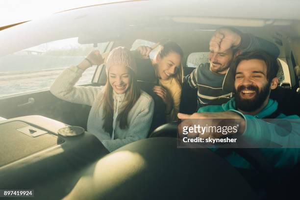 群快樂的朋友，享受樂趣，同時在車裡的客場之旅中跳舞。 - friends inside car 個照片及圖片檔