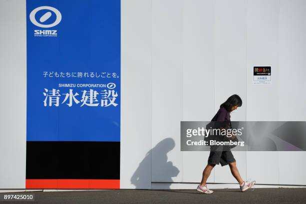 Pedestrian walks past the Shimizu Corp. Logo displayed on a fence at a construction site in Tokyo, Japan, on Friday, Dec. 22, 2017. Japan's major...
