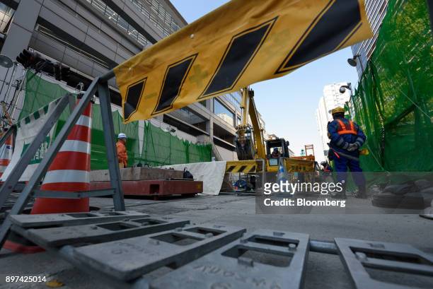 Workers labor at the construction site for magnetic levitation train tracks and platforms at Shinagawa Station in Tokyo, Japan, on Friday, Dec. 22,...