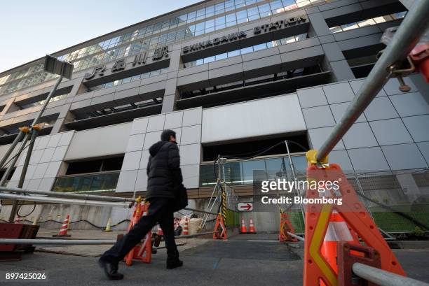 Pedestrian walks past the construction site for magnetic levitation train tracks and platforms at Shinagawa Station in Tokyo, Japan, on Friday, Dec....