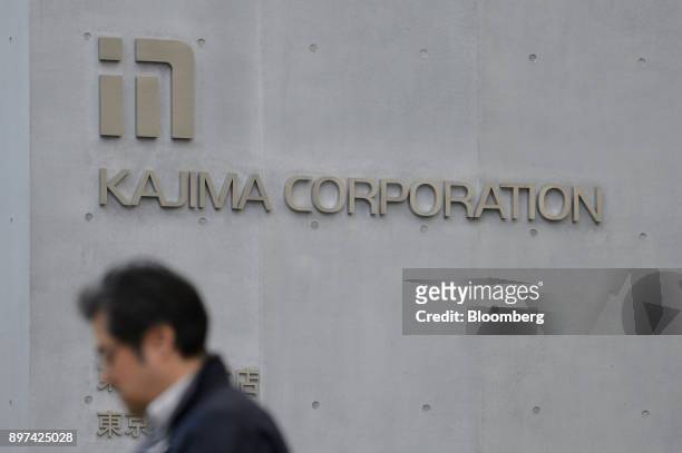 Pedestrian walks past a Kajima Corp. Logo displayed outside the company's headquarters in Tokyo, Japan, on Friday, Dec. 22, 2017. Japan's major...