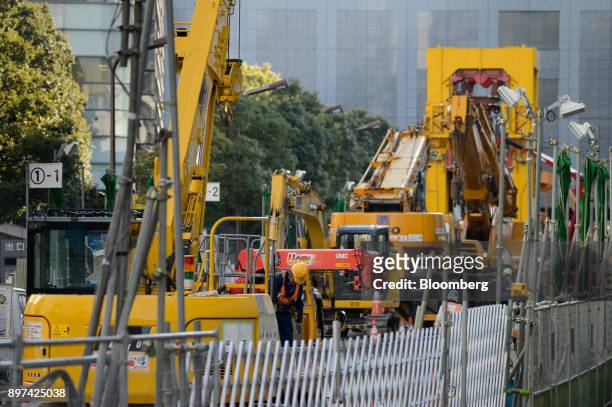 Workers labor at the construction site for magnetic levitation train tracks and platforms at Shinagawa Station in Tokyo, Japan, on Friday, Dec. 22,...
