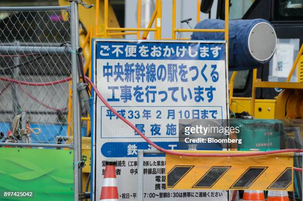 Signage stands at the construction site for magnetic levitation train tracks and platforms at Shinagawa Station in Tokyo, Japan, on Friday, Dec. 22,...