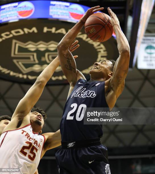 Eric Parrish of the Akron Zips hauls in a rebound ahead of Bennie Boatwright of the USC Trojans during the first half of their game at the Stan...