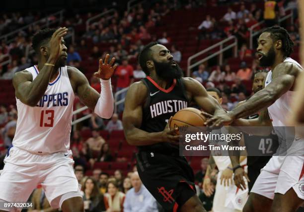 James Harden of the Houston Rockets drives to the basket defended by DeAndre Jordan of the LA Clippers and Jamil Wilson in the first half at Toyota...