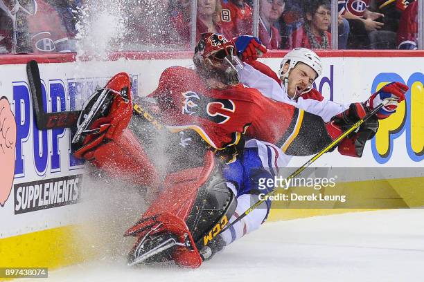 Andrew Shaw of the Montreal Canadiens collides with Mike Smith of the Calgary Flames during an NHL game at Scotiabank Saddledome on December 22, 2017...