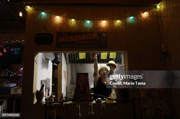 Workers stand beneath Christmas lights in the Andares Bistro on December 22, 2017 in Utuado, Puerto Rico. Owners said they opened their doors two...