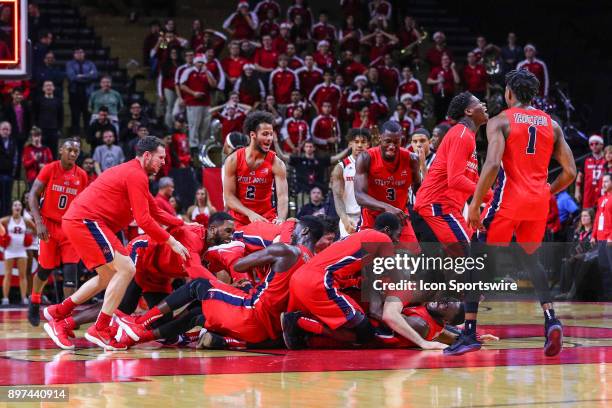 Stony Brook Seawolves forward Jakub Petras gets mobbed by his teammates after making the game winning basket of the College Basketball Game between...