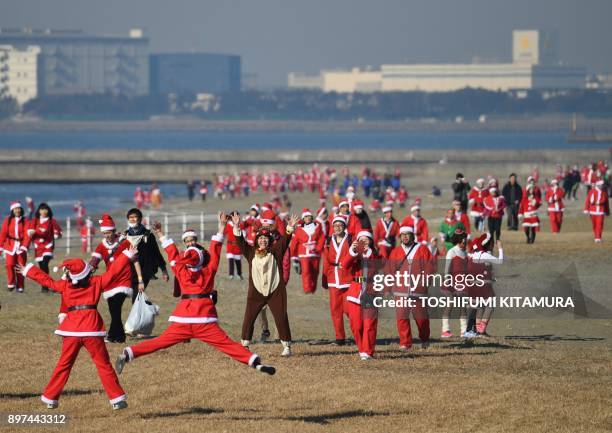 Runners in Santa Claus costumes take part in the Christmas charity event "Tokyo Santa Run" at the Makuhari Seaside Park in Chiba on December 23,...