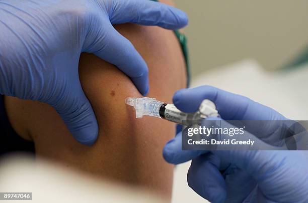 Marisa Grunder, 27 of Wilton, Iowa, is given a shot during trials of an H1N1 vaccine, developed by CSL of Australia, at University of Iowa Health...