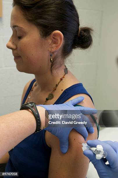 Marisa Grunder, 27 of Wilton, Iowa, is given a shot during trials of an H1N1 vaccine, developed by CSL of Australia, at University of Iowa Health...