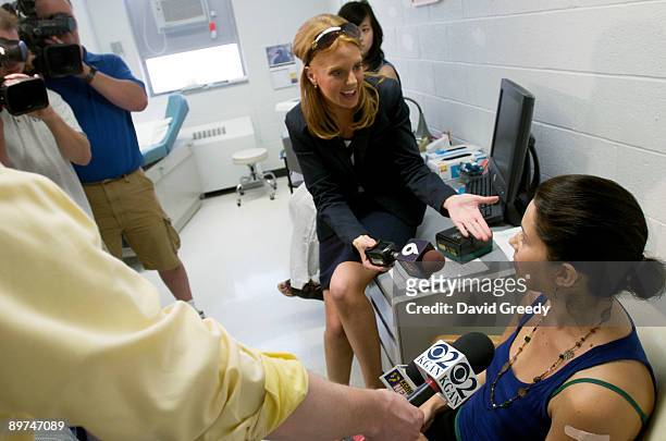 Marisa Grunder, 27 of Wilton, Iowa, speaks to the media after receiving an H1N1 vaccine, developed by CSL of Australia, during clinical trials at...