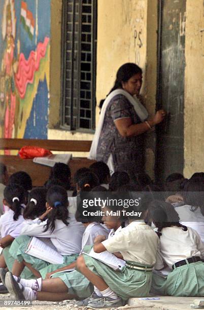 Children study outside their classrooms at an MCD school in New Delhi on Friday, August 7, 2009.