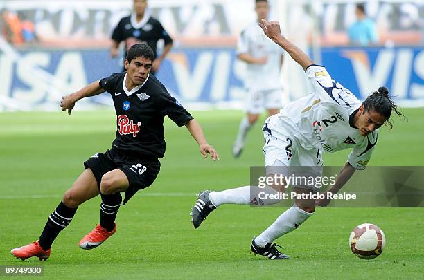Liga Deportiva Universitaria's Norberto Araujo vies for the ball with Libertad's Rodolfo Gamarra during their match as part of the 2009 Copa...