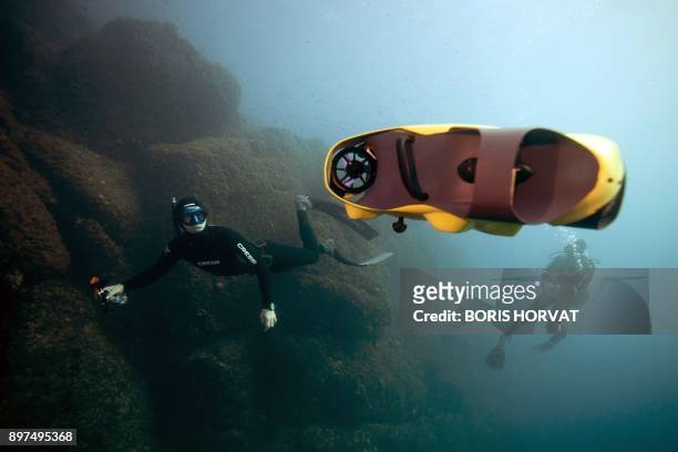 French diver Guillaume Nery uses the first submarine autonomous drone called "iBubble" on December 21, 2017 in order to run some tests during a...