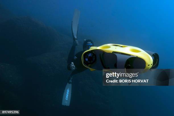 French diver Guillaume Nery uses the first submarine autonomous drone called "iBubble" on December 21, 2017 in order to run some tests during a...