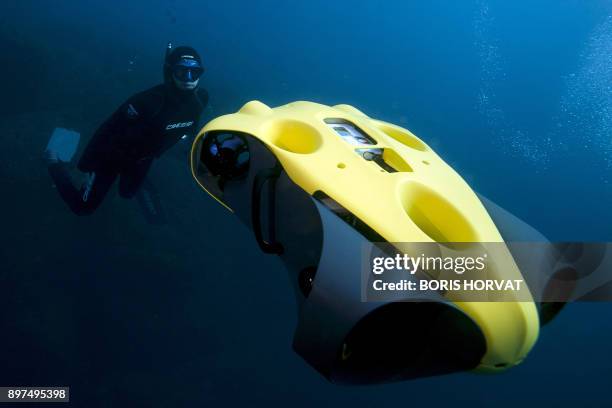 French diver Guillaume Nery uses the first submarine autonomous drone called "iBubble" on December 21, 2017 in order to run some tests during a...