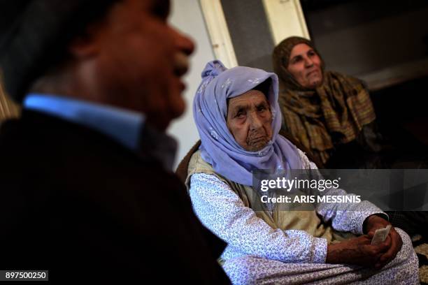 Laila Saleh, a 110 years old Syrian refugee from Kobane, looks on as she sits on the floor surrounded by members of her family, in an appartement in...