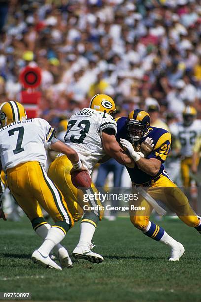 Linebacker Kevin Greene of the Los Angeles Rams puhes back offensive tackle Alan Veingrad of the Green Bay Packers to get to Packers quarterback Don...