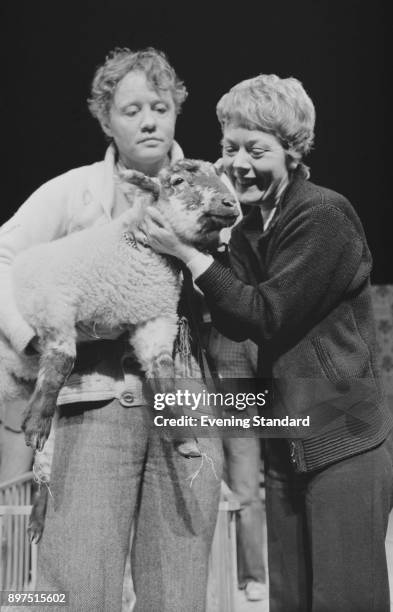 British actors Annette Crosbie and Dudley Sutton with a sheep, UK, 13th April 1977.