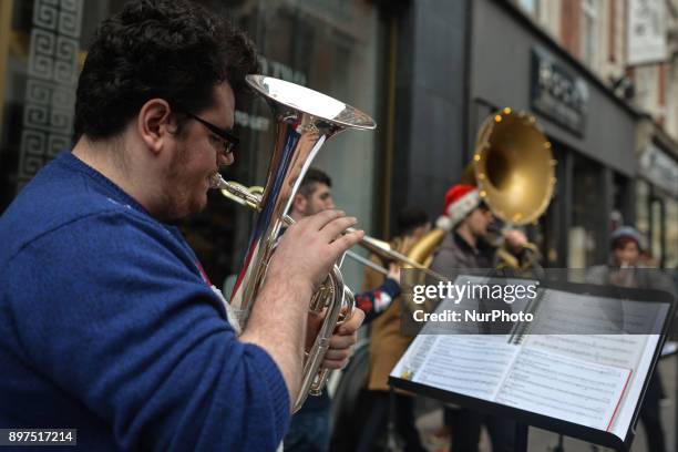 Group of local musicians using wind instruments busk on Grafton Street, in Dublin's city center. On Friday, 22 December 2017, in Dublin, Ireland.