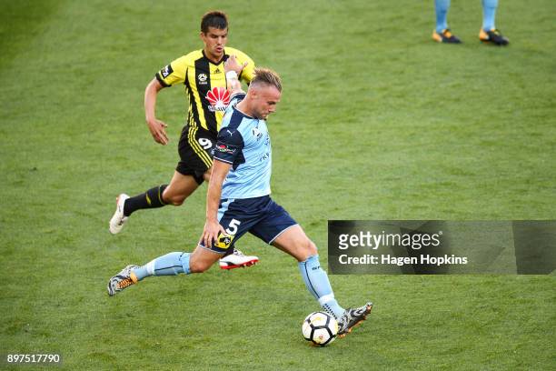 Jordy Buijs of Sydney FC passes under pressure from Andrija Kaludjerovic of the Phoenix during the round 12 A-League match between the Wellington...