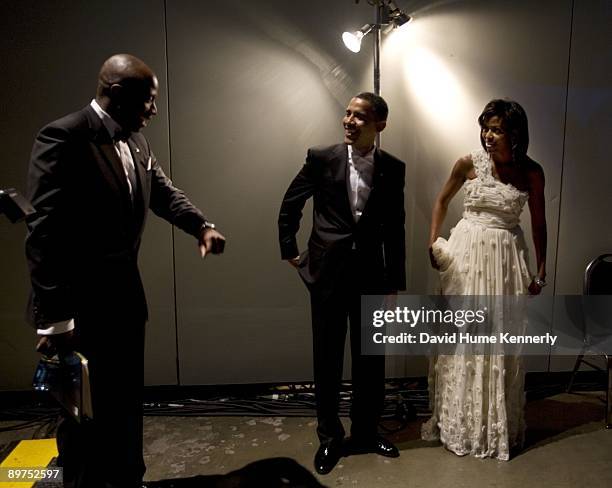 President Barack Obama and First Lady Michelle Obama enjoy a light moment as they wait backstage with Presidential Aide Reggie Love prior to their...