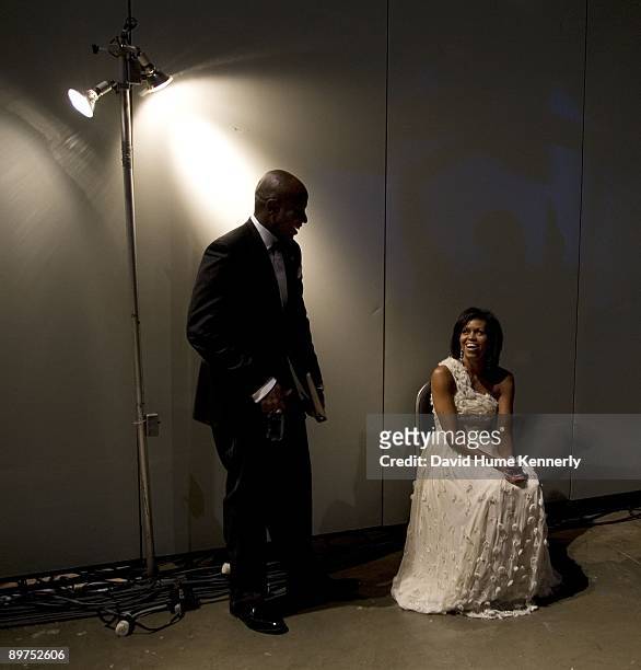 First Lady Michelle Obama takes a break with Presidential Aide Reggie Love prior to her grand entrance with husband President Barack Obama at one of...