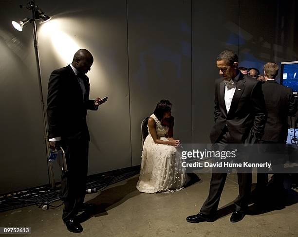 President Barack Obama and First Lady Michelle Obama wait backstage with Presidential Aide Reggie Love prior to their grand entrance to one of ten...