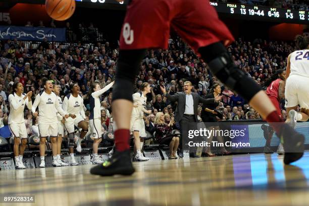 Head coach Geno Auriemma of the UConn Huskies on the sideline while recording his 1000th win as head coach of the team as the Uconn team celebrate a...