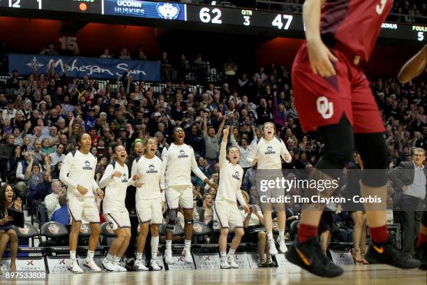 Head coach Geno Auriemma of the UConn Huskies on the sideline while recording his 1000th win as head coach of the team as the Uconn team celebrate a...
