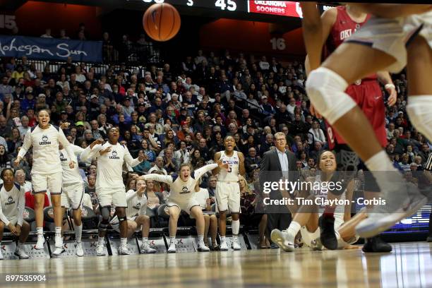 Head coach Geno Auriemma of the UConn Huskies on the sideline while recording his 1000th win as head coach of the team as the Uconn team celebrate a...