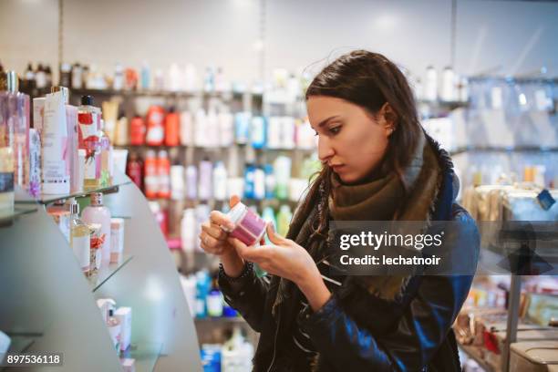 mujer de compras en la tienda de cosméticos - artículos de aseo fotografías e imágenes de stock