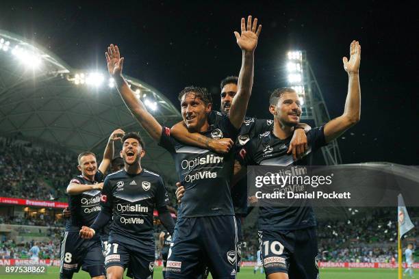 Mark Milligan of the Victory celebrates with teammates after kicking a goal during the round 12 A-League match between Melbourne City and Melbourne...