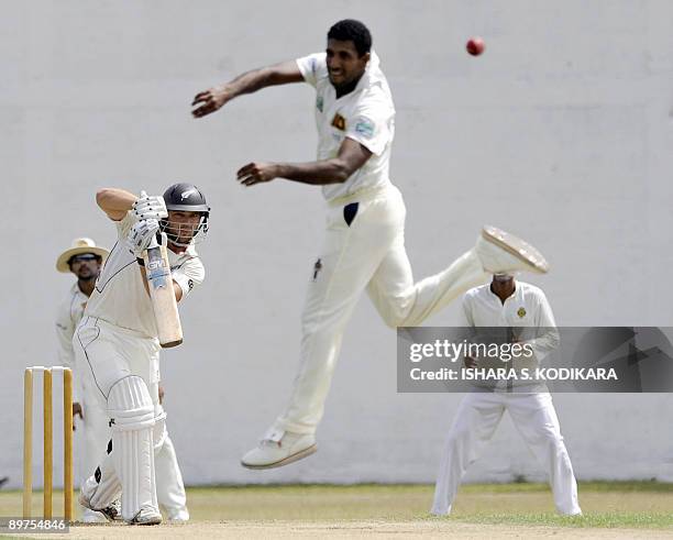 New Zealand cricketer Daniel Flynn is watched by Sri lankan bowler Dammika Prasad as he plays a stroke during the first day of a three-day practice...