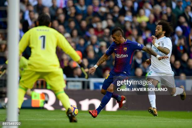 Barcelona's Brazilian midfielder Paulinho vies with Real Madrid's Brazilian defender Marcelo in front of Real Madrid's Costa Rican goalkeeper Keylor...