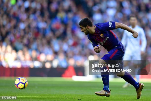 Barcelona's Uruguayan forward Luis Suarez runs with the ball during the Spanish League "Clasico" football match Real Madrid CF vs FC Barcelona at the...