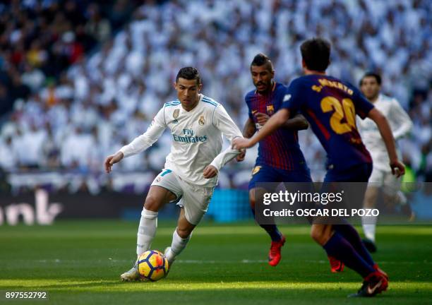 Real Madrid's Portuguese forward Cristiano Ronaldo runs with the ball during the Spanish League "Clasico" football match Real Madrid CF vs FC...