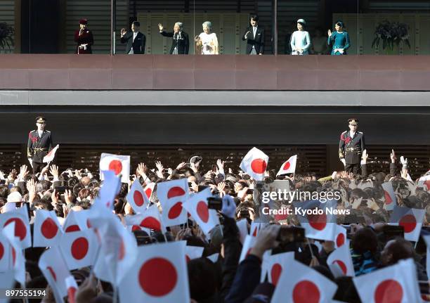 Japanese imperial family members wave to the crowd gathered to celebrate Emperor Akihito's 84th birthday at the Imperial Palace in Tokyo on Dec. 23,...