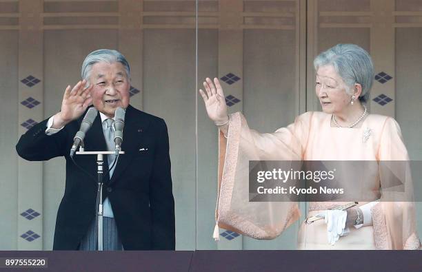Japanese Emperor Akihito , alongside his wife Empress Michiko, waves to the crowd gathered at the Imperial Palace in Tokyo to celebrate his 84th...