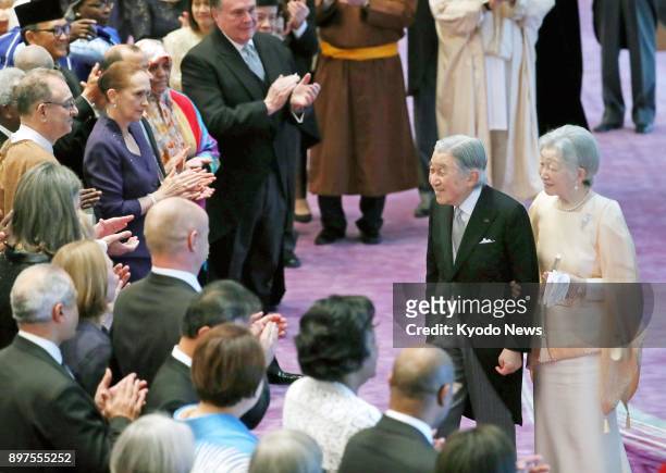 Japanese Emperor Akihito , accompanied by his wife Empress Michiko , is applauded by ambassadors to Japan during an event at the Imperial Palace in...