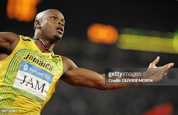 Jamaica's Asafa Powell celebrates as he crosses the finishline to win the men's 4×100m relay final at the "Bird's Nest" National Stadium during the...