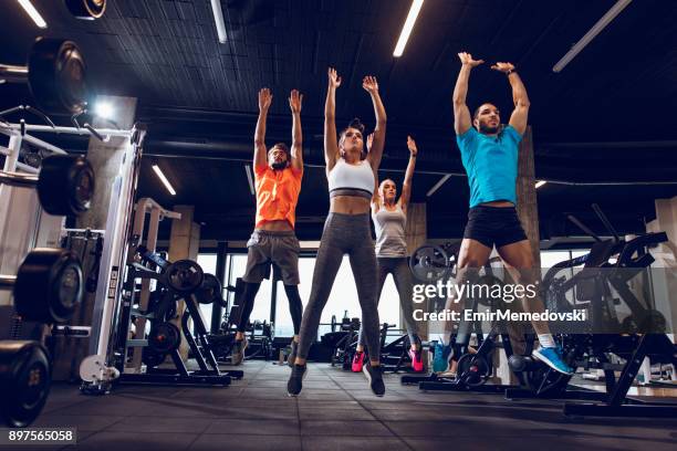 young people jumping during fitness class at the gym - sports team training stock pictures, royalty-free photos & images