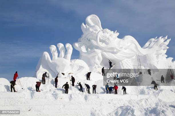 The giant snow sculpture featuring a dragon for Jingyuetan Vasaloppet International Skiing Festival is built by a team of about 100 snow carvers at...