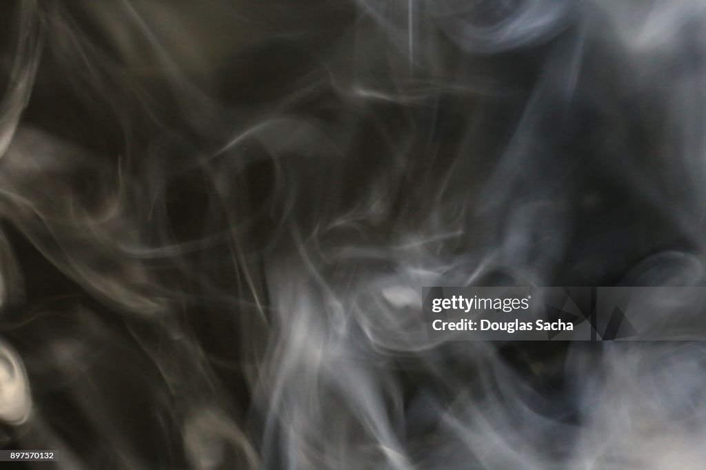 White smoke from a cigar on a black background