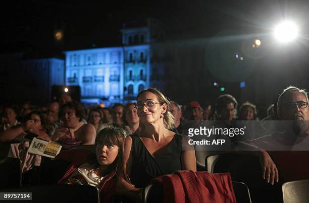Spectators seated infront of the giant screen at the Piazza Grande during the 62nd Locarno international film festival view a movie on late August...