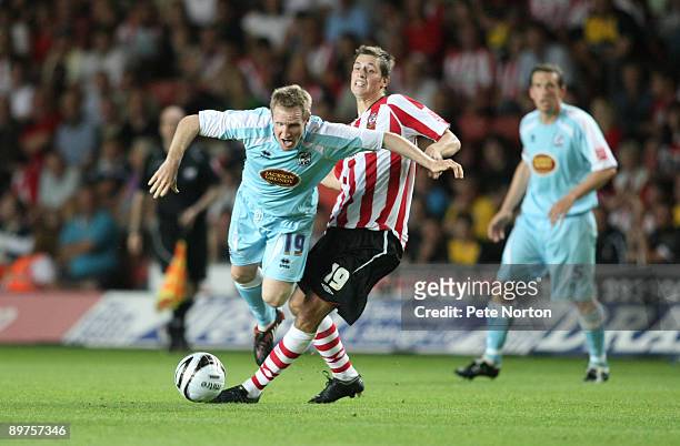 John Curtis of Northampton Town is brought down by the challenge of Morgan Schneiderlin of Southampton during the Carling Cup Round One Match between...