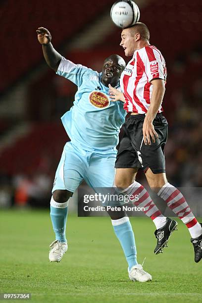 Olly Lancashire of Southampton heads the ball under pressure from Adebayo Akinfenwa of Northampton Town during the Carling Cup Round One Match...